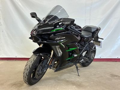 a black motorcycle parked in front of a white backdrop