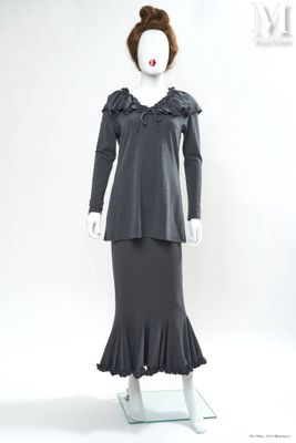 Le mannequin porte une robe noire ornée de volants.