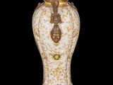 a white vase with gold decoration on it on a black background