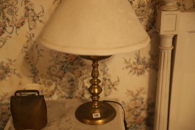 une lampe posée sur une table à côté d'un téléphone