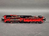 a red train on the tracks on a gray surface