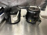 two black and silver appliances sitting on a metal counter