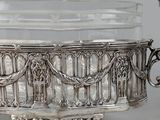 an antique silver plate with a glass bowl on top of it
