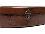 étui en cuir marron muni d'un fermoir, sur fond blanc
