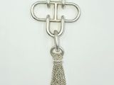 a close up of a silver cross with a tassel on a chain