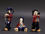 three figurines of a man with a camera and a woman with a dog