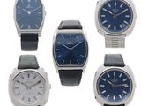 four different styles of watches with blue dials on a white background