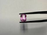 someone is holding a pair of pliers with a pink stone in it