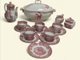 un service de table rouge et blanc comprenant un bol, des tasses, des soucoupes et des soucoupes