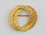 a close up of a gold brooch with a circular design