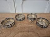 four silver plated ashtrays on a wooden table