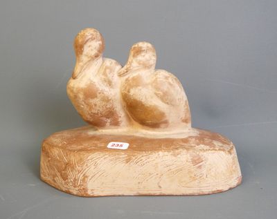 une statue représentant deux oiseaux perchés sur un bloc de bois