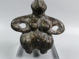 an image of a statue of a woman sitting on a glass base