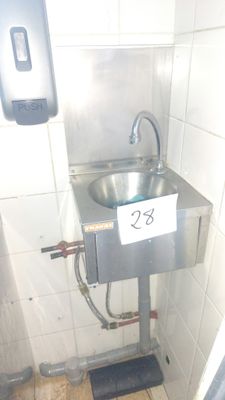 a metal sink in the corner of a bathroom