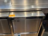a stainless steel counter with a glass of water on it