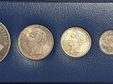 six different coins in a blue case with a white background
