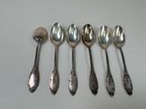 six spoons are lined up in a row on a table