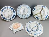 six blue and white plates with designs on them sitting on a table