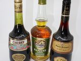three bottles of liquor are lined up on a white surface