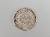 a close up of a silver coin on a white surface