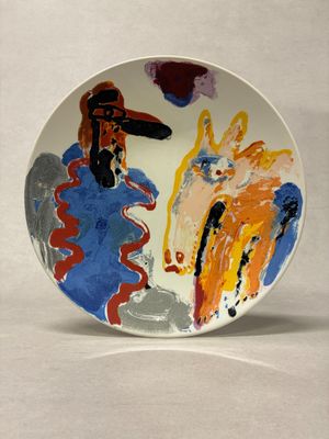 a plate with a painting on it on a white surface