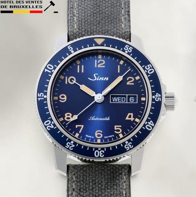 La montre est bleue et argentée, avec un cadran noir.