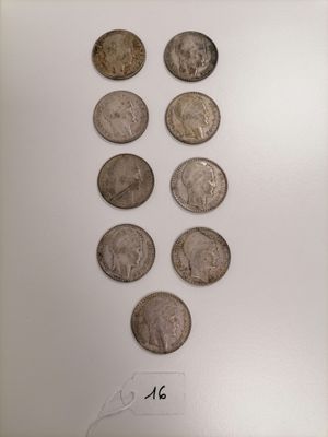 a group of six different types of coins on display in a glass case