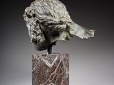 a close up of a sculpture of a head on a marble base
