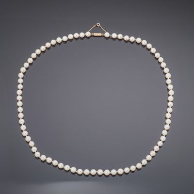 a white pearl necklace with a gold clasp