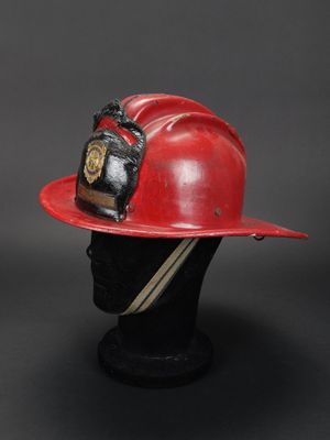 casque de pompier posé sur la tête d'un mannequin, sur fond noir