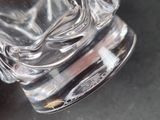 a glass vase with a statue on it on a table