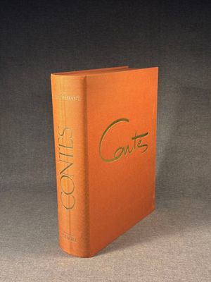 an orange book sitting on top of a table next to a black background