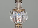 a glass perfume bottle with a gold decoration on it