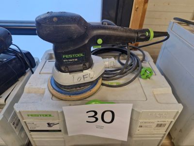 une ponceuse posée sur une boîte