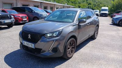 La voiture grise est garée sur un parking avec d'autres voitures.