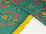 an image of a close up of a green scarf with a yellow border