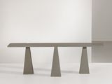 une table en béton à trois pieds posée sur une surface blanche