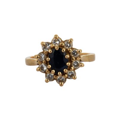 a close up of a gold ring with a black stone surrounded by white diamonds