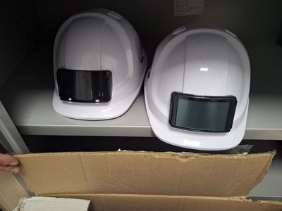 pair of white hard hats sitting on top of a cardboard box