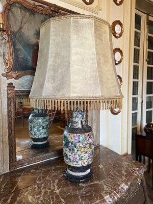 une table sur laquelle se trouve une lampe, avec un miroir en arrière-plan