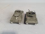 two toy tanks sitting next to each other on a table