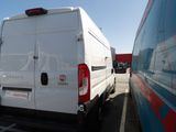 a white van parked in a parking lot next to a blue van