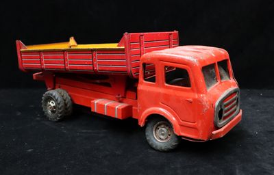 a red toy truck with a yellow top on a black background