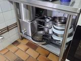stainless steel counter with pots and pans on top of it in a kitchen
