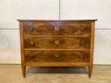 a wooden chest of drawers sitting on top of a cement floor