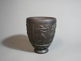 un vase noir orné d'un motif, posé sur une table