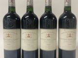 quatre bouteilles de vin sont alignées sur une surface blanche