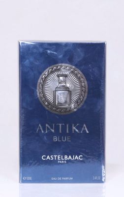 l'image d'une boîte de parfum bleue posée sur une table blanche