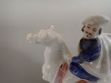 a figurine of a man riding on a horse