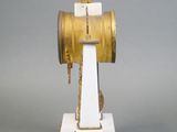 a white and gold clock with a bird on top of it